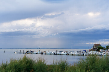 Fototapeta na wymiar Beautiful and peaceful evening over the small sea harbour with blue clouds and coast line