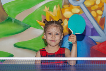 Happy child holding ping pong racket