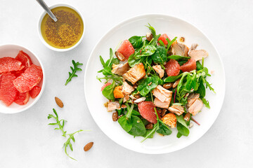 Grilled salmon salad with grapefruit, almonds and salad mix. Top view