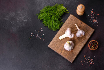 Heads of fresh white garlic on a wooden cutting board