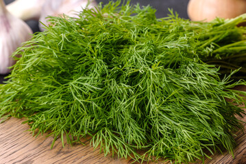 A bunch of fresh green dill on a wooden cutting board