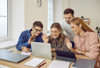 Smiling diverse young people talk on video call on computer with friend or colleague. Happy multiracial teenagers have webcam communication on internet on laptop. Virtual digital event.