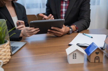 Business people having a meeting in office with laptop and architectural models.