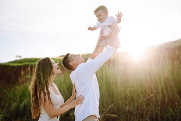 Fototapeta premium Father, mother and child resting on the beach. Young family are having fun on summer vacation. Travel, nature, active lifestyle, resort concept.