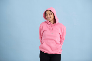 Studio portrait of young woman wearing pink hoodie