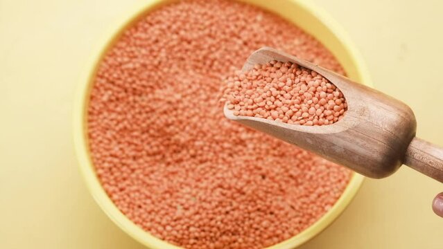 Bowl of uncooked dhal on white,