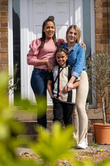 Portrait of mothers and son in front of house