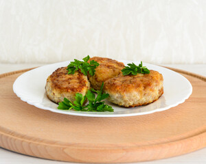 Beefsteaks garnished with fresh herbs on a white plate. Dinner. Ukrainian cutlets.