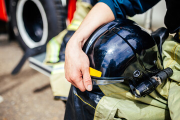 Black helmet in fireman's hand close-up