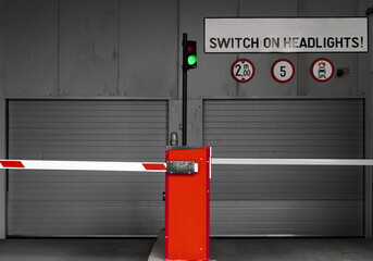 Subterranean parking garage entry gate with switch on headlights sign