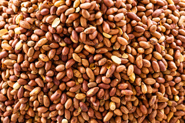 Red unpeeled peanuts panoramic view background