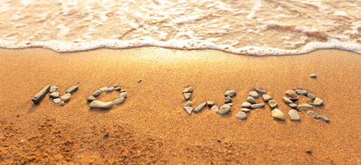 Words written in the sand on the beach. The words No War and written in the Sand with the Ocean in the background. Protest War sign written in sand. World Peace. No War