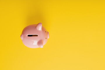 Piggy bank on a yellow background. Top view
