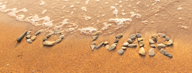 Words written in the sand on the beach. The words No War and written in the Sand with the Ocean in the background. Protest War sign written in sand. World Peace. No War