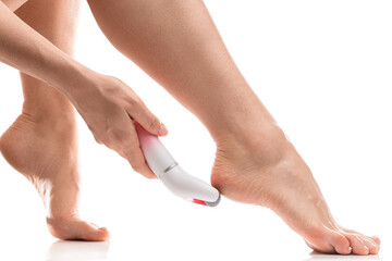 Female feet and electric foot file for callus and dead skin removal on white background