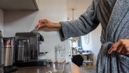Midsection of man wearing bathrobe using coffee maker