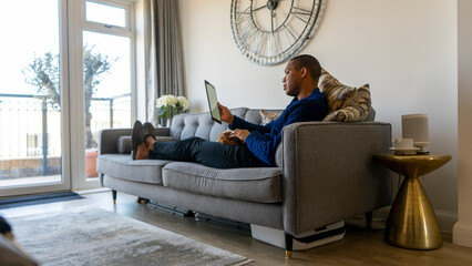 Man sitting on sofa using digital tablet