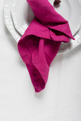 Fuchsia linen napkin on the white dish
