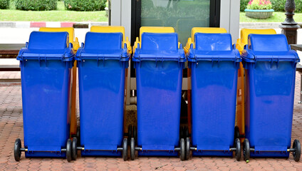 Blue and Yellow Plastic Trash are located in rows on the worm walkway,  Thailand.