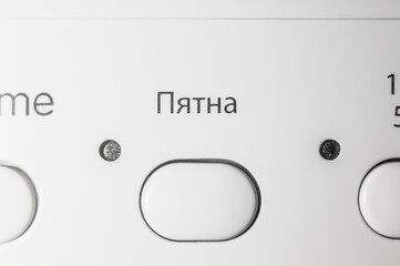 Button to turn on the mode operation of the removal of dirty spots. Control panel of a modern washing machine. Russian interface. Selective focus. Translation of the text in Russian language - Spots.