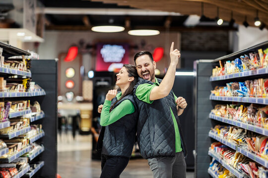Playful employees dancing in supermarket.
