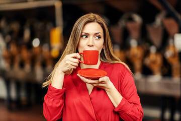 An elegant woman drinking coffee in coffee factory.