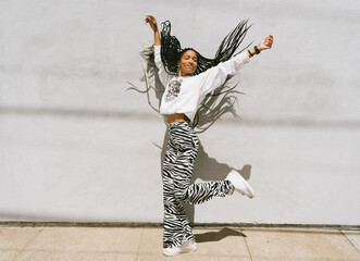 Young woman with long dreadlocks dancing