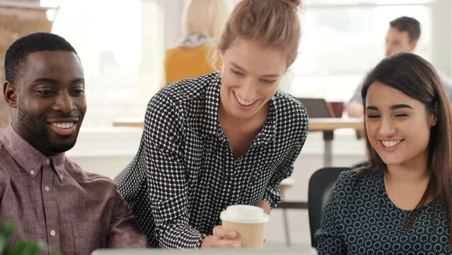 a group of businesspeople brainstorming during a meeting. A young businesswoman collaborating with her diverse colleagues holding a cup of coffee. Professional coworkers talking in a meeting video