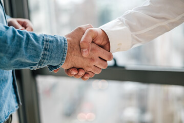 Close up shot of teamwork handshake in the office businessman entrepreneur freelancer shaking hands...