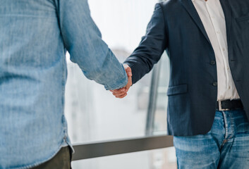 Close up shot of businessmen entrepreneurs freelancers shaking hands greeting each other making a successful new deal and start of collaboration on the new mutual project