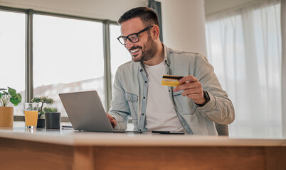Concentrated caucasian man, checking his account balance, cheerful and smiling.