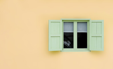 Vintage opened green mint shutters and wooden windows isolated on yellow background with copy space and clipping path.