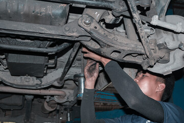 The mechanic is checking the engine.