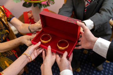 Wedding couple holding a box of gold bangles, gifts from parents. Chinese wedding with 