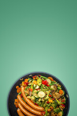Cover page with ceramic frypan with a mix of Mediterranean diet vegetables and sausages, with...