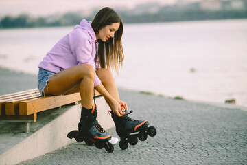 Young attractive woman with roller skates in park
