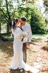 Fototapeta premium beautiful young couple kissing each other on their wedding day, happy and in love young people.