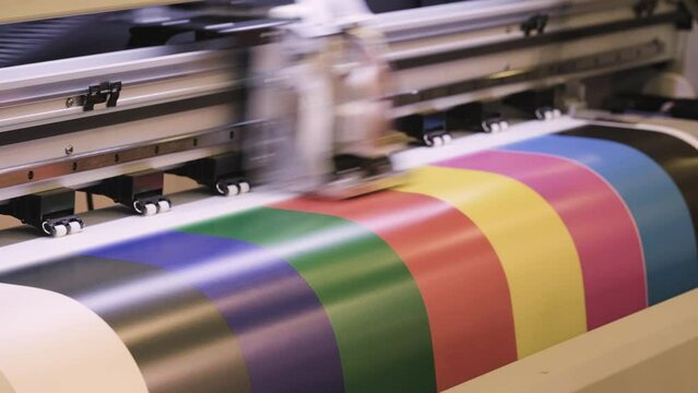 Industrial printing on paper, modern digital inkjet printer puts a picture on paper