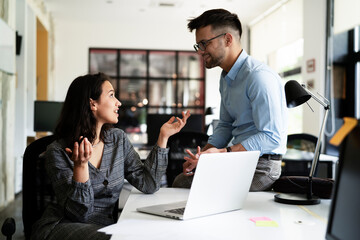 Colleagues in office. Businesswoman and businessman discussing work in office.