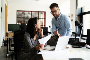 Colleagues in office. Businesswoman and businessman discussing work in office.