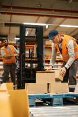 Distribution warehouse workers organizing packages at storage compartment.