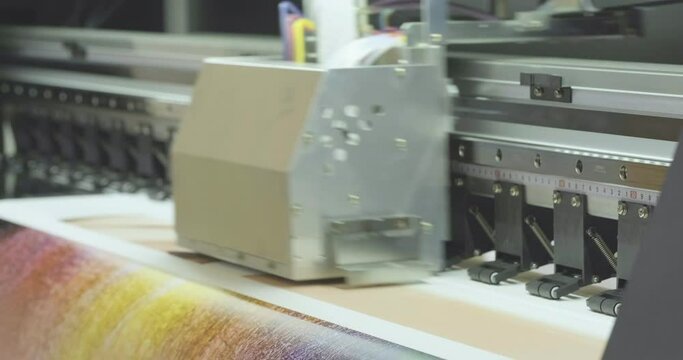 Industrial printing on paper, modern digital inkjet printer puts a picture on paper