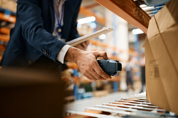 Close up of warehouse inspector scanning packages at storage compartment.