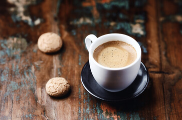 Cup of coffee with Amaretti (Italian biscuits) on rustic wooden background. Copy space.
