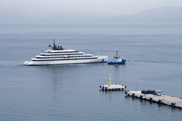 Luxury white yacht escorted by a police boat on Mediterranean Sea