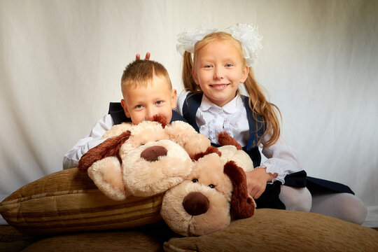 Girl and boy who is elementary school children in uniform having fun with toys Brother and sister on September 1 in Russia. Schoolgirl and schoolboy relax together. Photo shoot for the school holiday