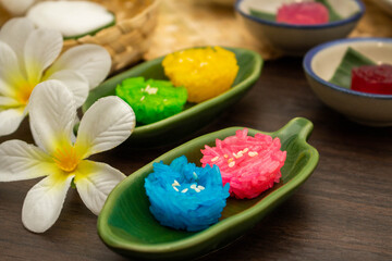 Obraz na płótnie Canvas Thai traditional dessert concept, Colorful glossy sticky rice on banana leaf plate on wooden table