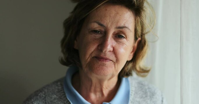Portrait senior woman face looking at camera with serious expression