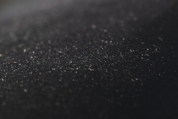 Black abstract background with a close-up pattern of plastic texture. Selective focus