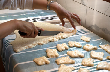 Preparation of traditional Kazakh pastries - baursaks. The woman cuts the dough into pieces. High quality photo